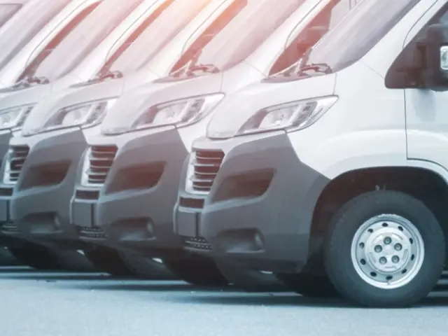 Larga fila de furgonetas blancas para pasajeros